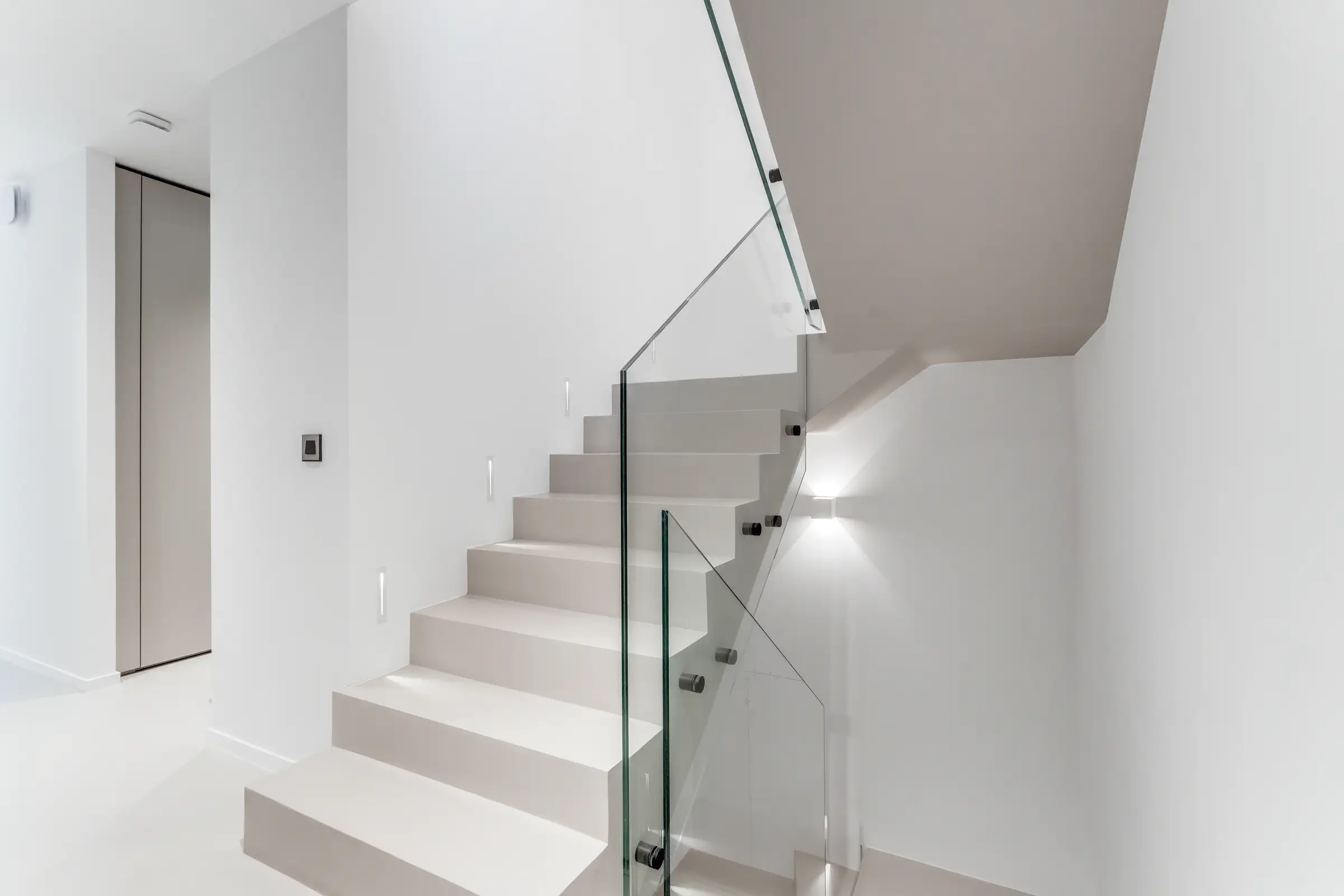 L’escalier intérieur, marches claires et garde-corps de verre